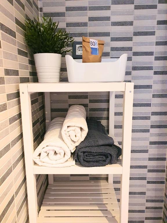 półka z ręcznikami i roślina w łazience w obiekcie Precioso Estudio con Piscina w Maladze