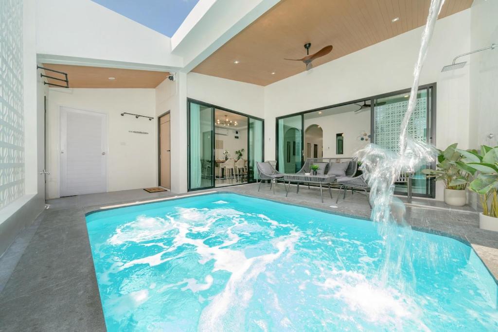 an indoor swimming pool with a water fountain in a house at 6BR Patong pool villa in Patong Beach