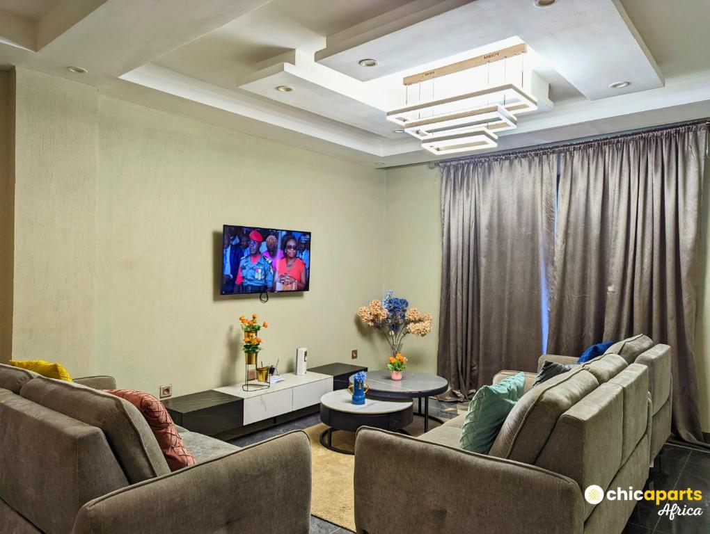a living room with two couches and a tv at Chic apart with parking near the airport in Douala