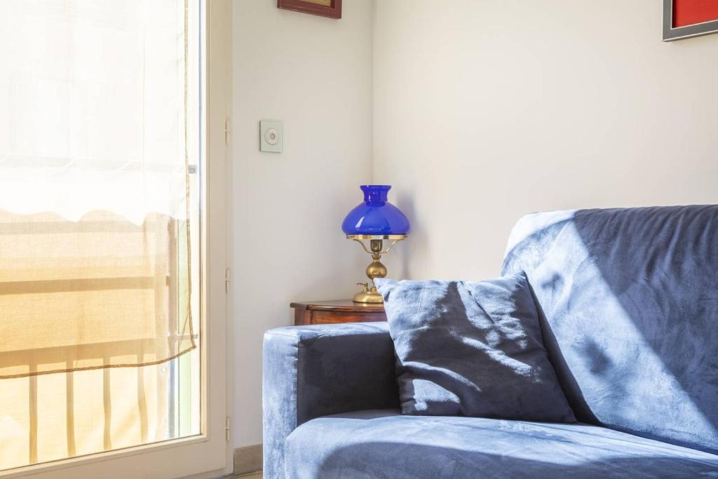 a blue chair sitting next to a window with a blue vase at Superbe T2 refait à neuf proche du centre du village et de la Mer in Porquerolles