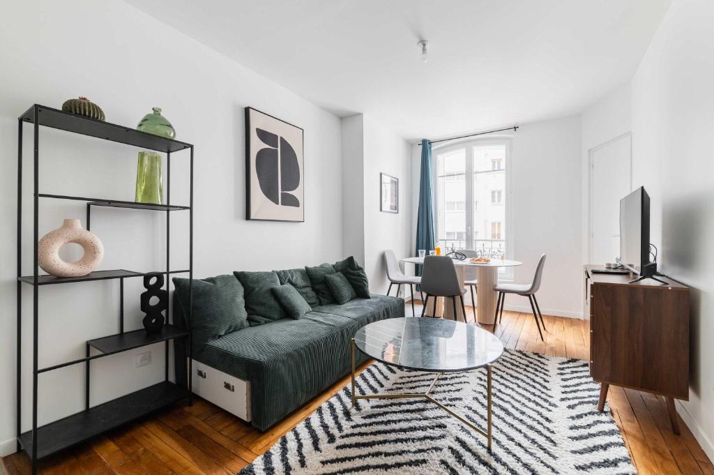 un salon avec un canapé vert et une table dans l'établissement Cosy 2 Pieces au Coeur du 19e - 4P, à Paris