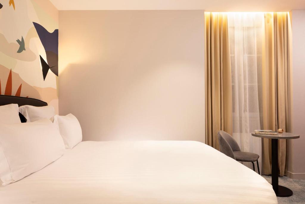 Postel nebo postele na pokoji v ubytování Hôtel Le Nautilus