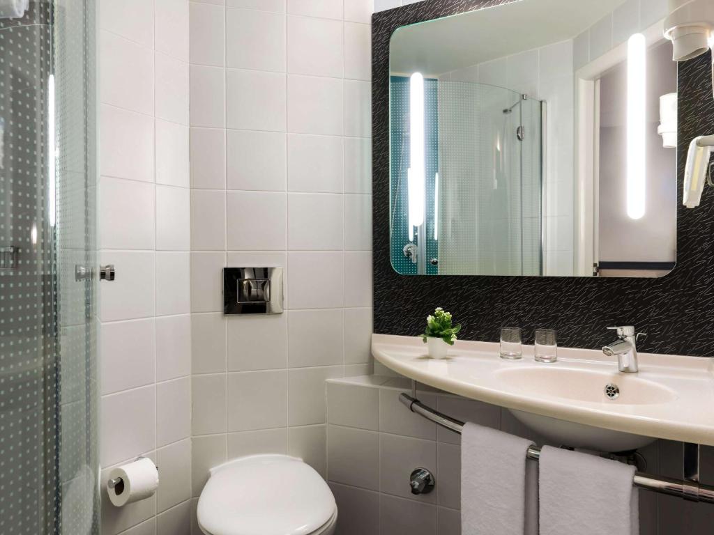 a bathroom with a sink and a toilet and a mirror at ibis Ankara Airport Hotel in Ankara