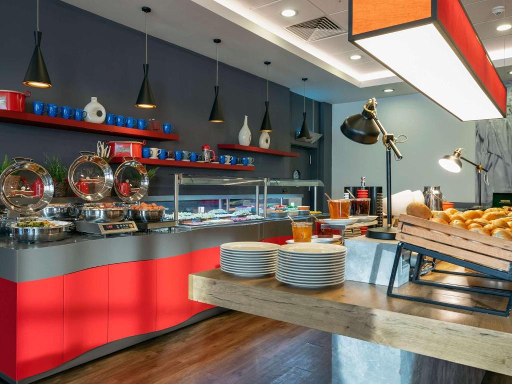 a restaurant with a counter with plates on it at ibis Ankara Airport Hotel in Ankara