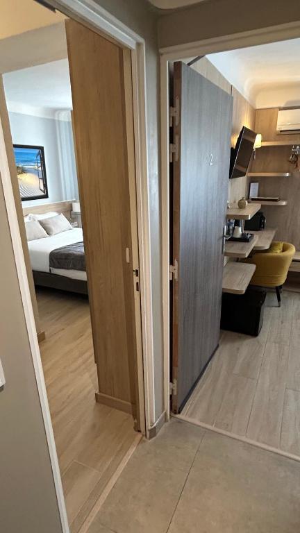 an open door to a room with a bedroom and a bed at Hotel Miramar- Cap d'Antibes - La Garoupe plage in Antibes