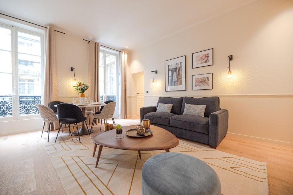 un salon avec un canapé et une table dans l'établissement Luxury Central 3 Bedrooms Flat - Grands Boulevards, à Paris