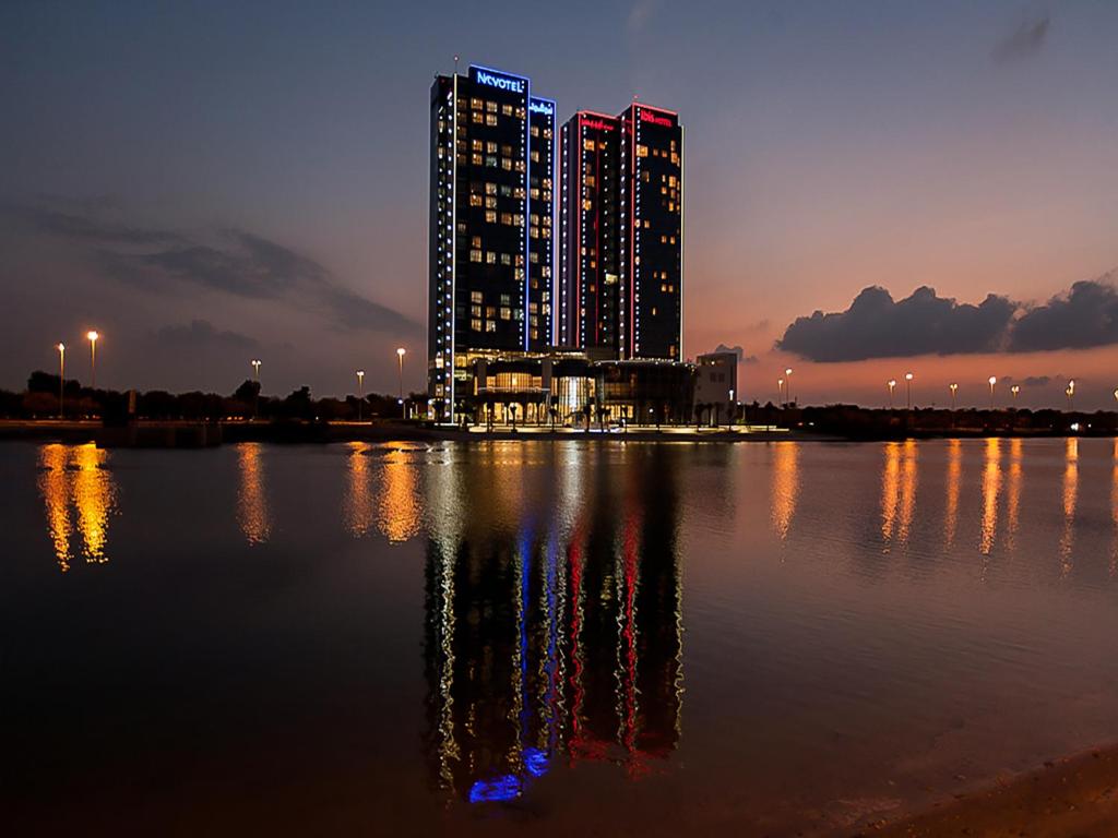 eine Skyline der Stadt mit einem großen Gebäude im Wasser in der Unterkunft Ibis Abu Dhabi Gate in Abu Dhabi