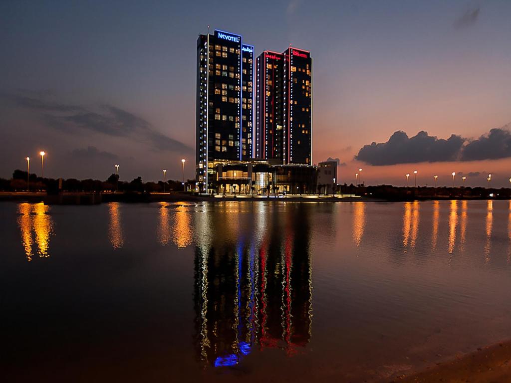 a city at night with a large body of water at Ibis Abu Dhabi Gate in Abu Dhabi