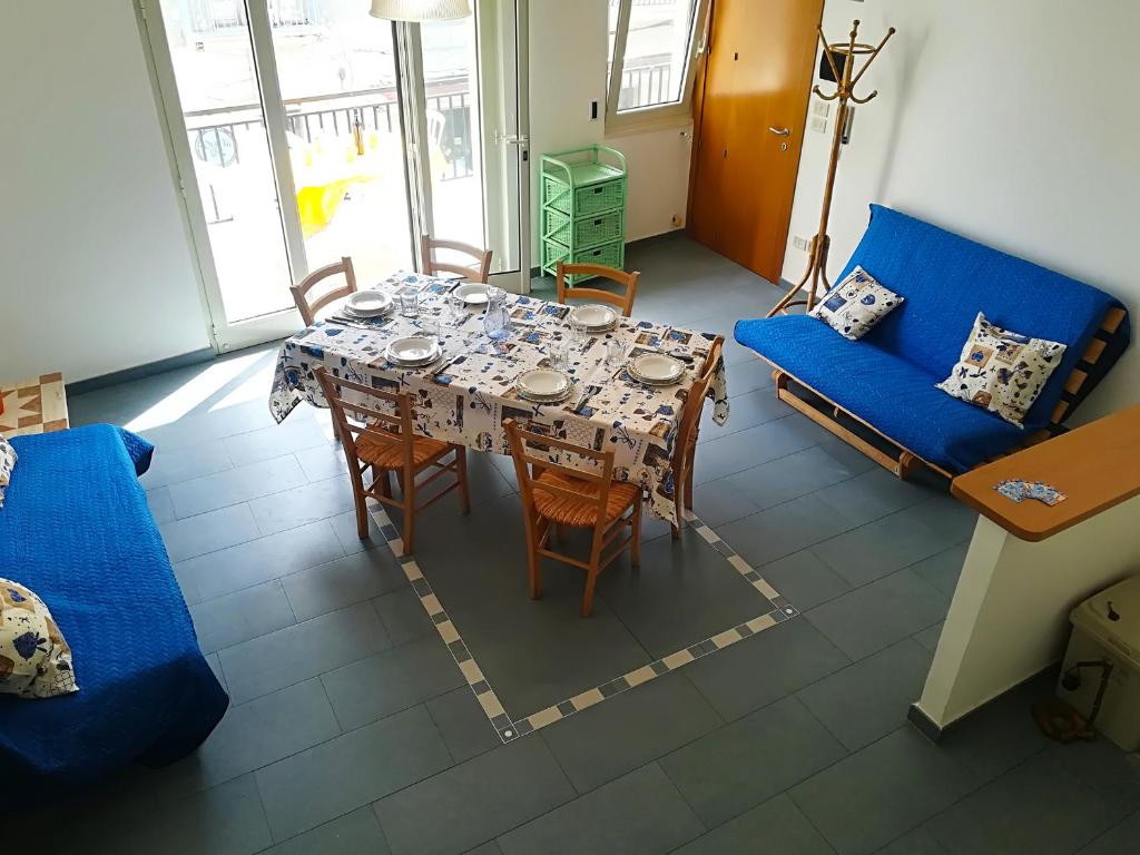 a living room with a table and a blue couch at Afr0dite'home Historic Center Otranto Seafront in Otranto