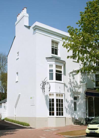 a white building with a car parked in front of it at Orla Restaurant & Rooms in Lindfield