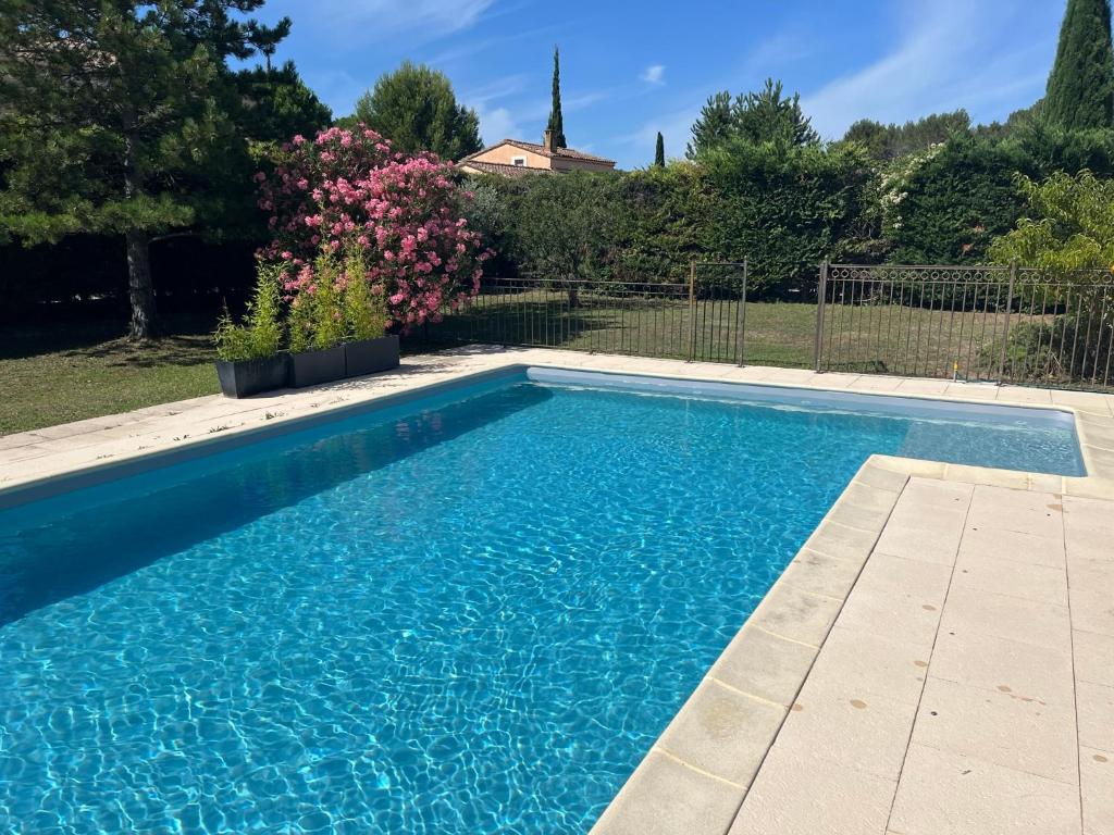 une piscine avec de l'eau bleue dans une cour dans l'établissement Villa climatisée avec piscine et aire de jeux enfants, à Pernes-les-Fontaines