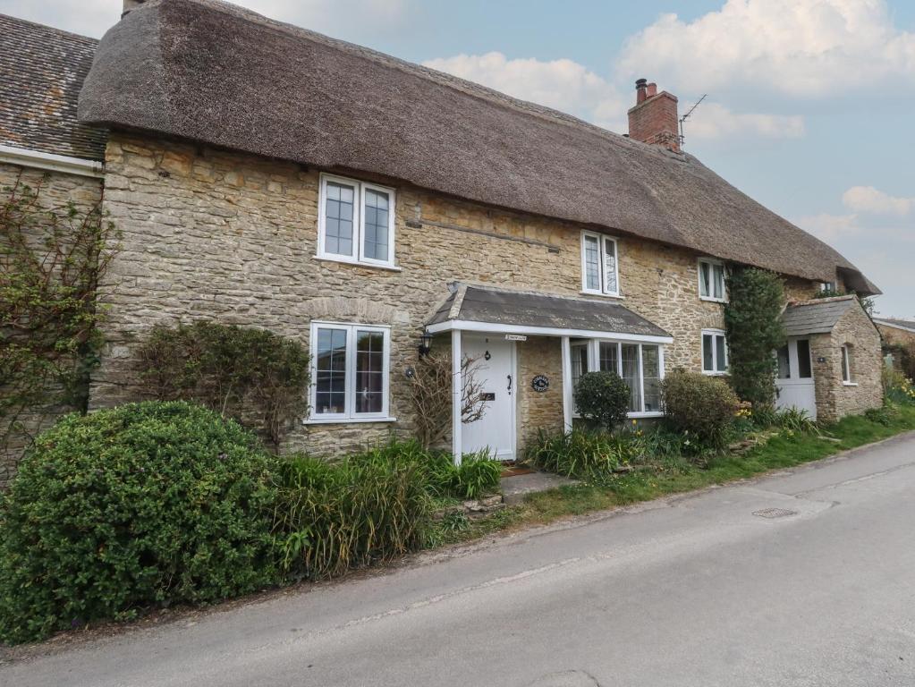 ein altes Steinhaus am Straßenrand in der Unterkunft Cobblers Cottage in Weymouth
