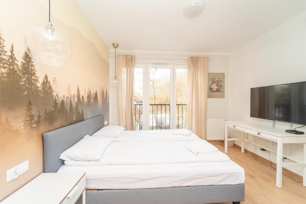 a bedroom with two beds and a desk and a tv at Comfortable 3city Studios in Sopot by Noclegi Renters in Sopot
