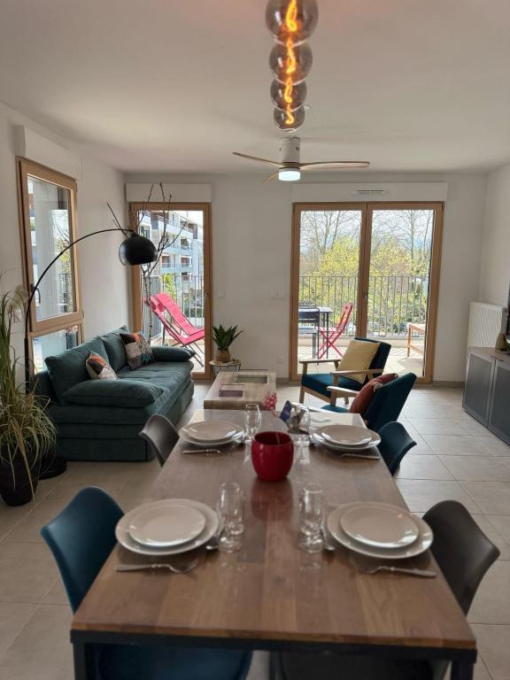 un salon avec une table et des chaises en bois dans l'établissement La parenthèse du lac - Lake view and private parking, à Aix-les-Bains