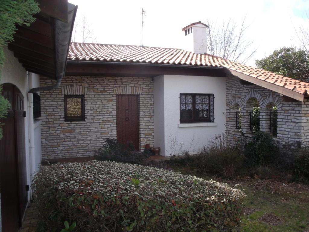 une petite maison en briques avec une porte rouge dans l'établissement Capriga, à Arès