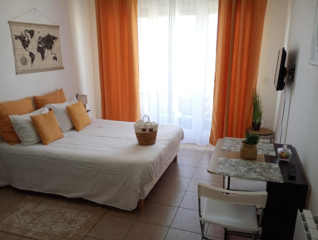 a bedroom with a bed and a table and a window at B301 Disney Paris AppartementAppartement in Montévrain