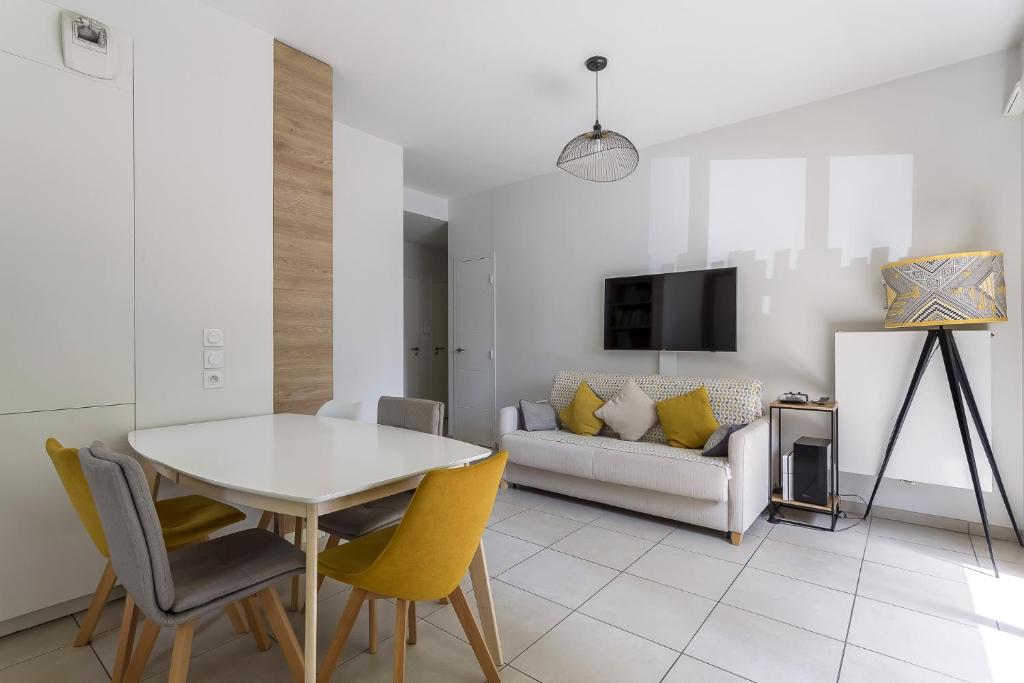 un salon avec une table, des chaises et un canapé dans l'établissement DIFY Sedallian - Vaise, à Lyon