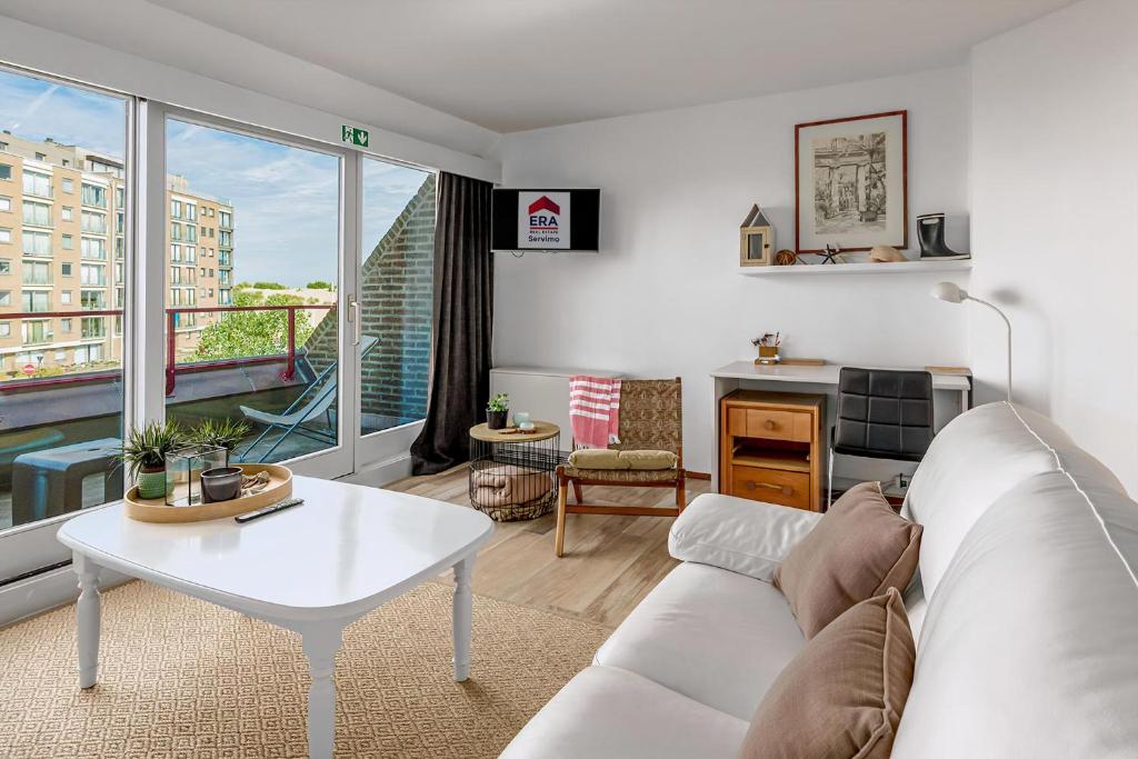 科克赛德Zeezonzand 0202的客厅里有一张白色的沙发和一张桌子