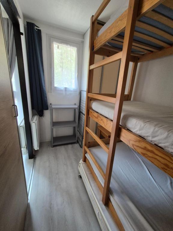 a room with two bunk beds and a window at Résidence les Mélèzets 2 au pieds des pistes et des commerces in Modane