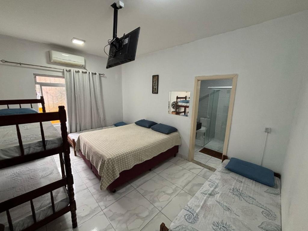 Suítes Yellow House BC في باليريو كامبوريو: غرفة نوم بها سرير وتلفزيون