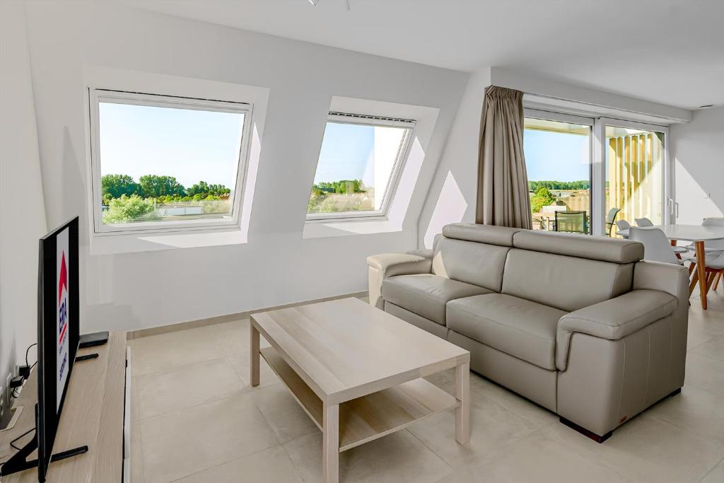a living room with a couch and a tv at Villa Zephir O3O5G 221 in Nieuwpoort