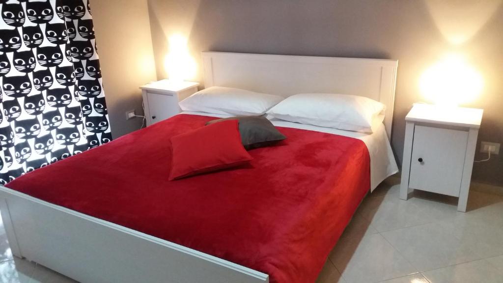 een slaapkamer met een groot bed en een rode deken bij Studio Notte in Telese