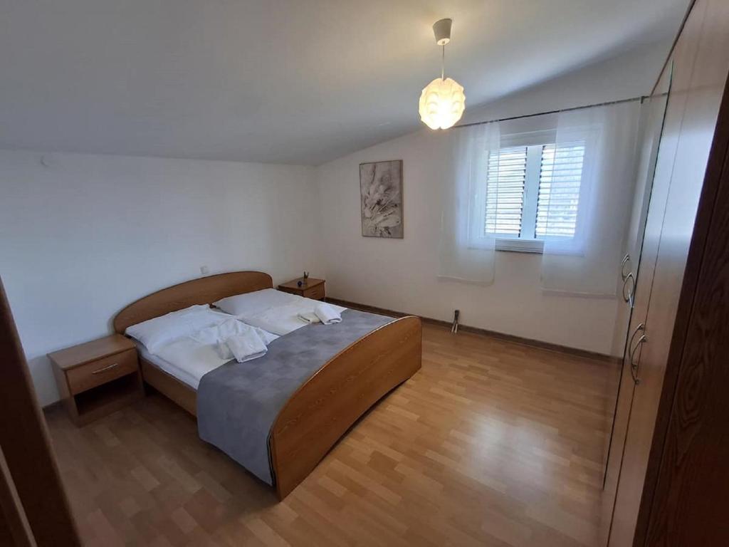 a bedroom with a large bed and a window at Holiday Home Iva & Luca in Stankovci