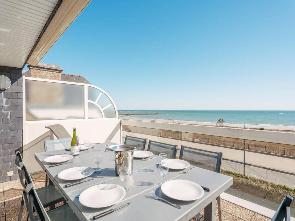 une table blanche avec des chaises et une vue sur la plage dans l'établissement Carnac - Triplex 2 pièces + mezzanine, 85m², 1 chambre, Parking, Proche plage - FR-1-477-84, à Carnac