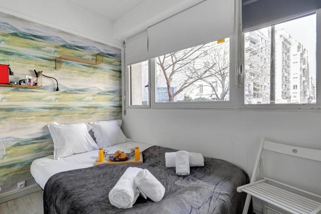 - une chambre avec un lit et un plateau de nourriture dans l'établissement 5017 Suite Vignes - Cozy studio, à Paris