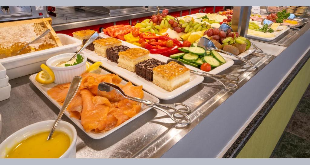 a buffet filled with different types of food on a counter at PLAZA INN Regensburg in Regensburg