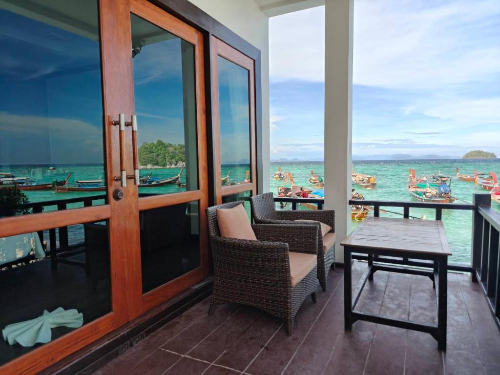 a balcony with chairs and a table and the ocean at Cabana Lipe Beach Resort in Ko Lipe