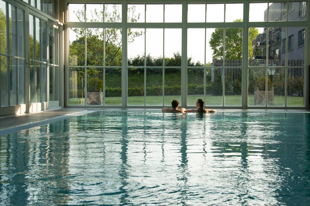 zwei Personen in einem Schwimmbad in einem Gebäude in der Unterkunft Schloss Basthorst in Crivitz