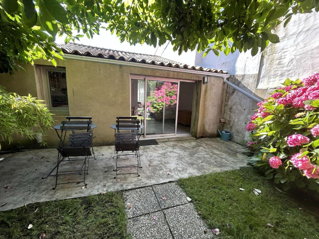 d'une terrasse avec des chaises et une table dans la cour. dans l'établissement Maison rénovée 4 couchages avec jardinet, à 2000 m des plages - Noirmoutier-en-l'Île - FR-1-224B-1, à Noirmoutier-en-l'lle