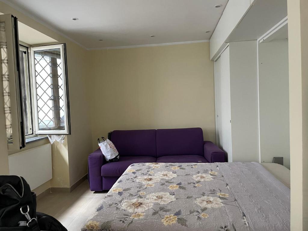 a bedroom with a purple bed and a purple couch at Casa Sermoneta in Naples