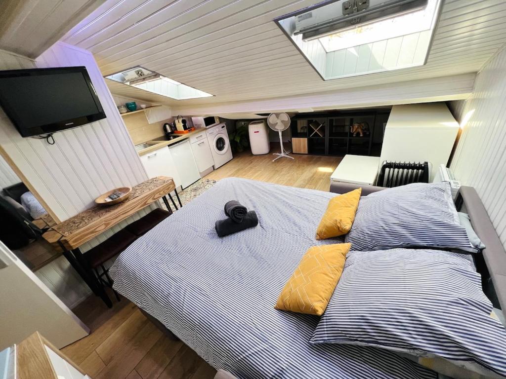 une chambre avec un grand lit avec des oreillers jaunes dans l'établissement Charmand studio mansardé dans le centre ville de Cannes, à Cannes