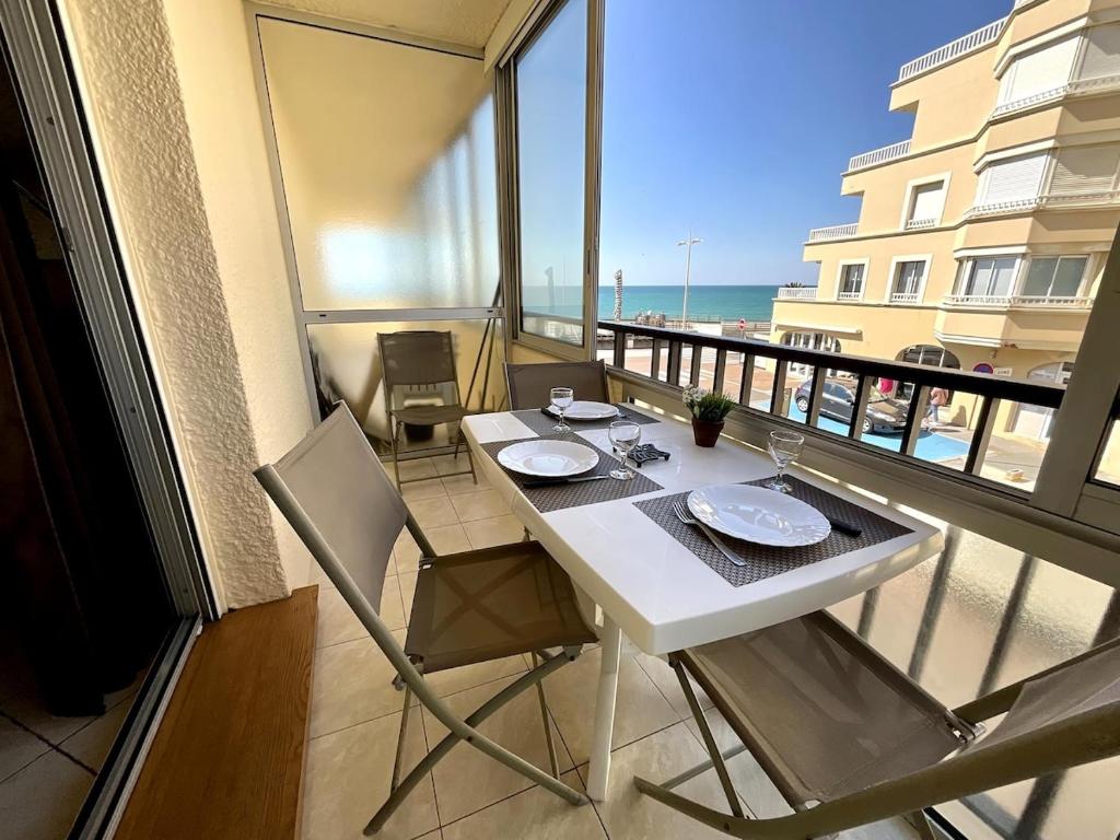 - une table et des chaises blanches sur un balcon donnant sur la plage dans l'établissement Studio Ocean, à Capbreton