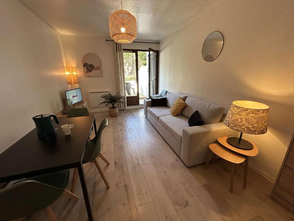 un salon avec un canapé et une table dans l'établissement Appartement T2 avec Jardin, à 200m de la Plage - 6 Couchages, Saint-Hilaire-de-Riez - FR-1-224C-314, à Saint-Hilaire-de-Riez