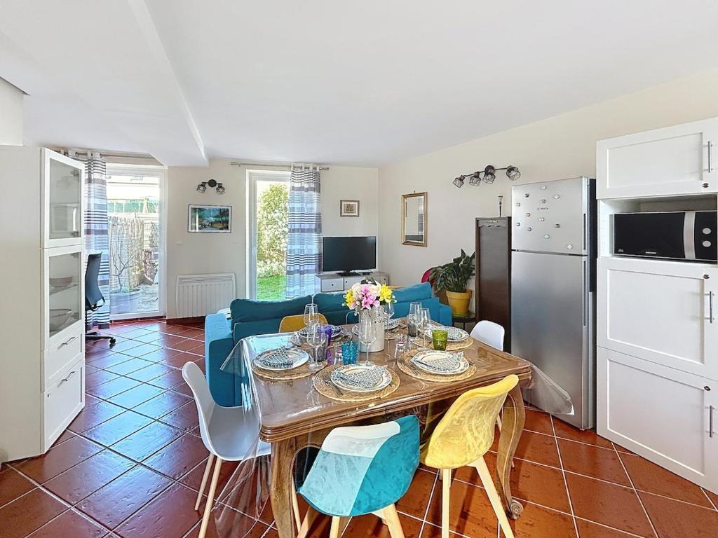 a kitchen and living room with a table and chairs at La Maison des Hirondelles in Lachelle