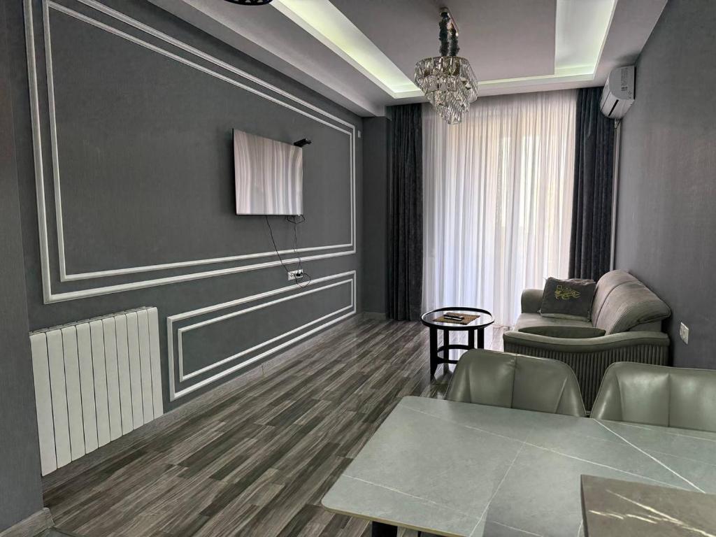 a living room with a table and a chair at Crystal Apartments in Tbilisi City