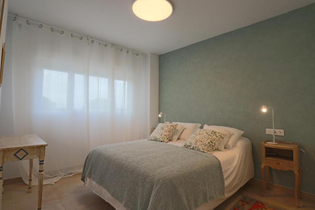 a bedroom with a bed and a large window at Nice apartment next to the golf in El Portil