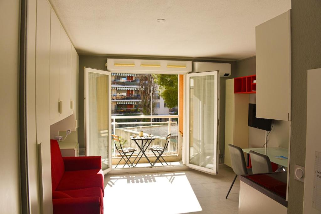 - un salon avec un canapé rouge et une porte ouverte dans l'établissement Studio avec terrasse à Nice, à Nice