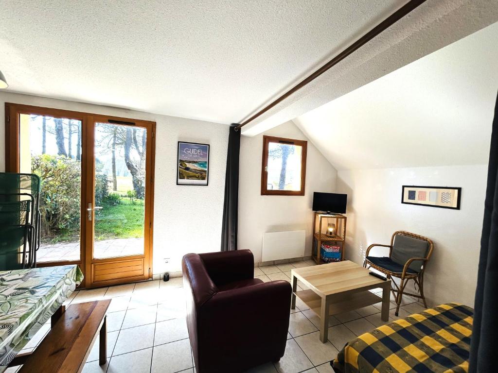 - un salon avec un canapé, une chaise et une table dans l'établissement Maisonnette 6 pers- Piscine commune - Plage à 500 m- LOEIZ, à Guidel-Plage