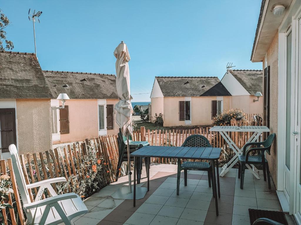 a patio with a table and chairs and a fence at VVF Golfe du Morbihan Sarzeau Arzon in Sarzeau