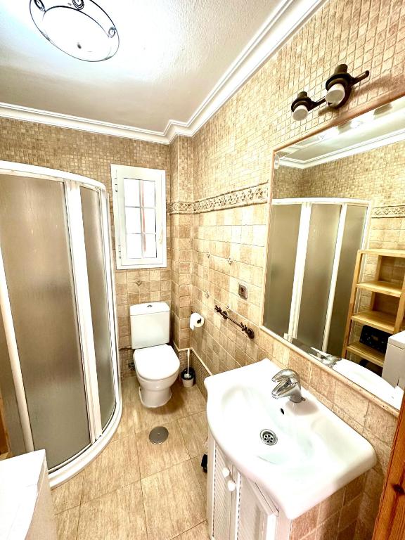 a bathroom with a sink and a toilet and a shower at Apartamento a pie de playa en El Portil in El Portil