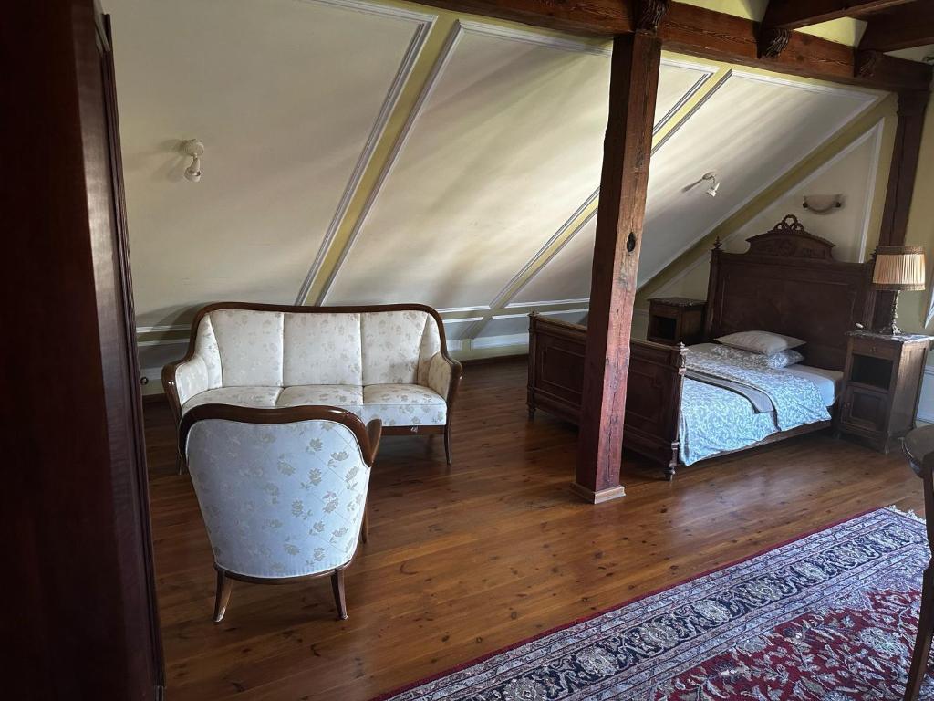 a bedroom with a bed and a chair in a room at Pałac Sapetów in Tuczno