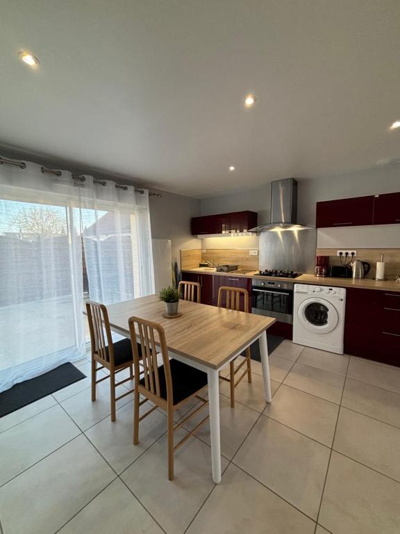 a kitchen with a wooden table and chairs in it at Maison de charme avec cour privée in Chaingy
