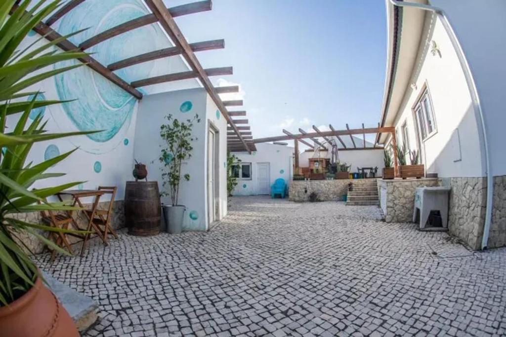 a courtyard of a white building with a tile floor at Charming House with Shared Pool in Atalaia, 110 m² in Lourinhã