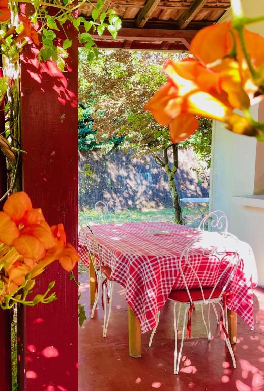 - une table et des chaises rouges et blanches sur la terrasse dans l'établissement Charmante maison authentique, proche bassin, à Arès