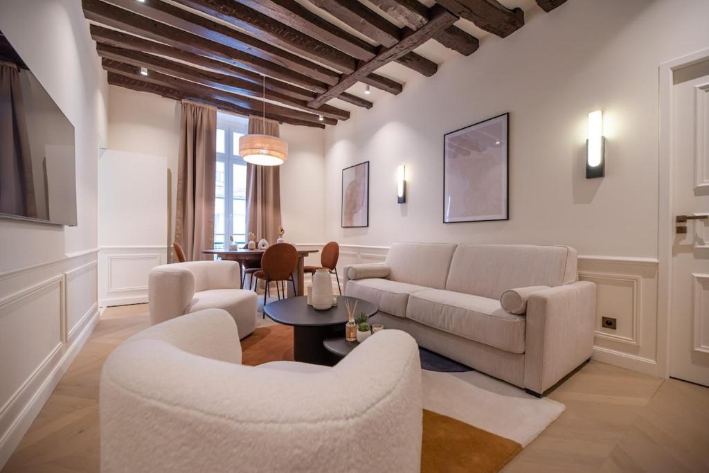 un salon avec un canapé, des chaises et une table dans l'établissement Appartement de luxe d'une chambre près du Louvre II, à Paris