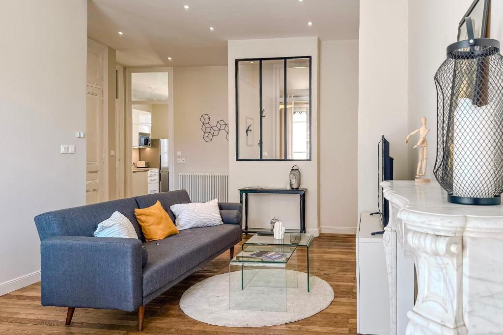 un salon avec un canapé bleu et une table dans l'établissement #HW Le Mazet Hyper-centre Haussmanian apartment, à Grenoble